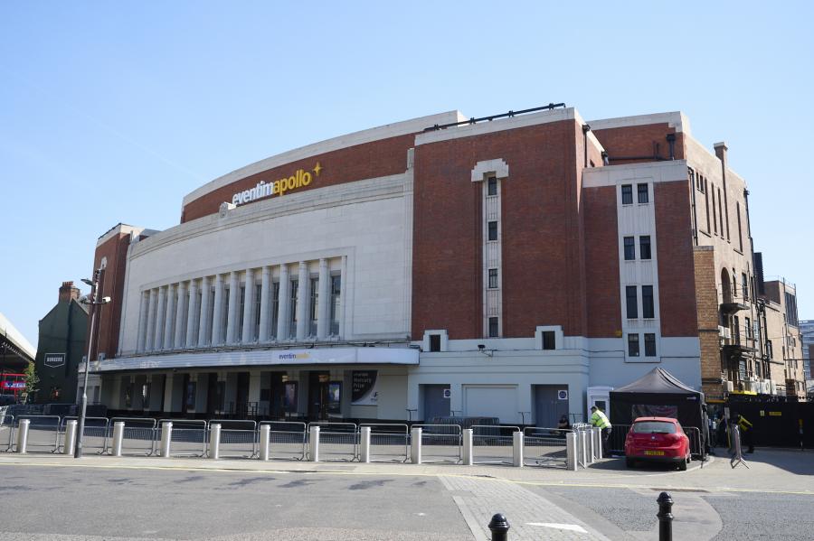 a black and white image of the eventim apollo. it is an art deco style building. the image shows the entrace to the building. 